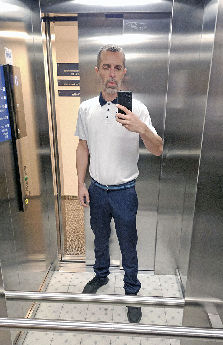 Ivan Kralj in bell boy uniform in a hotel elevator.