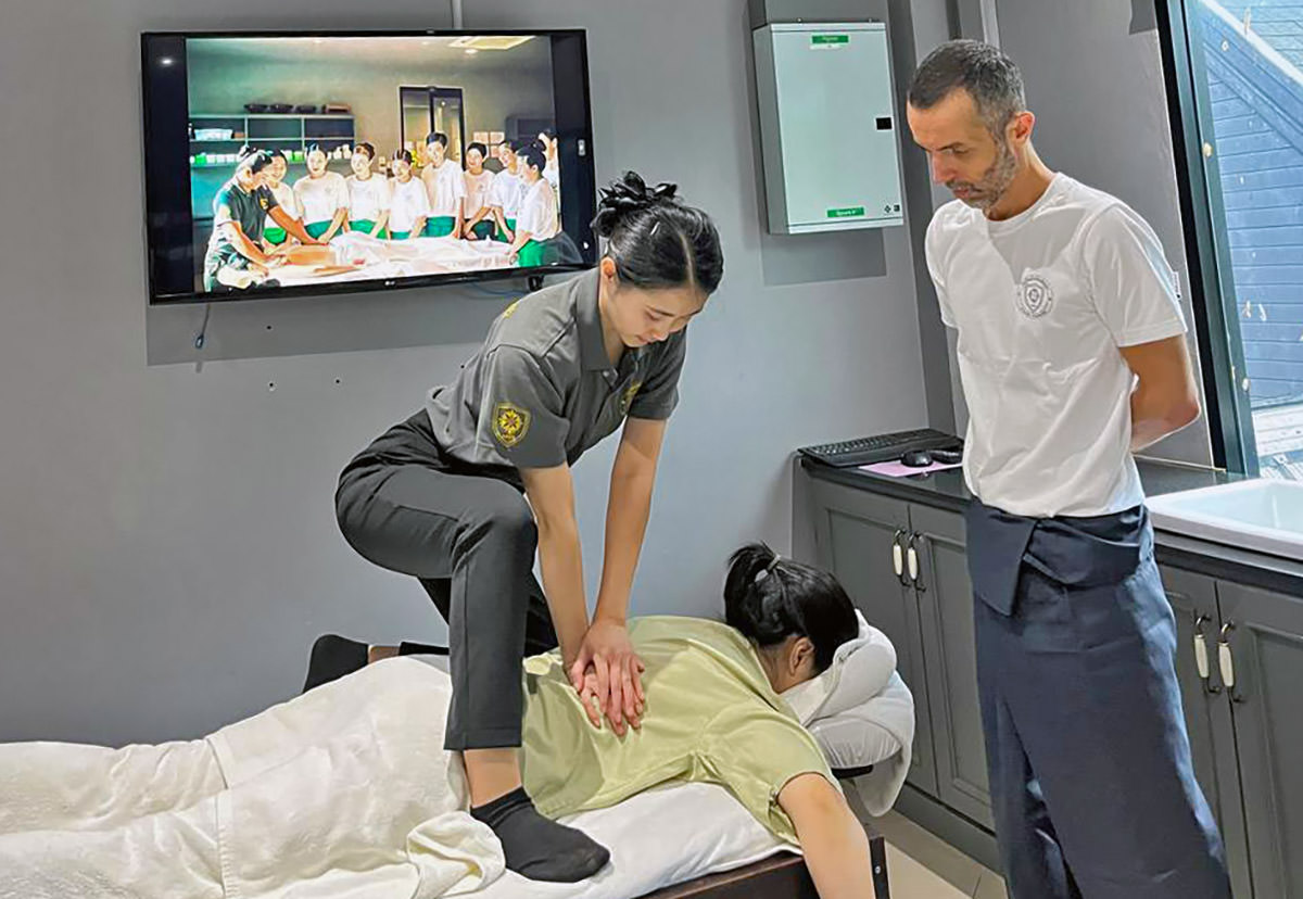 Nigel Amonrat Paojae demonstrating the massage technique to travel blogger Ivan Kralj at Thai Oasis Spa School in Chiang Mai, Thailand.