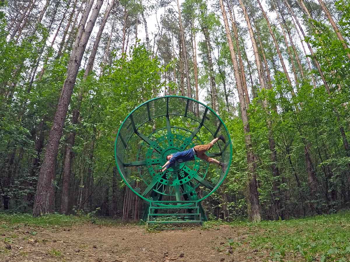 Travel blogger Ivan Kralj spinning in "Carousal", a human 'hamsterl wheel', an artwork by Marius Zavadskis installed at Europos Parkas, the geographical center of Europe; photo by Ivan Kralj.