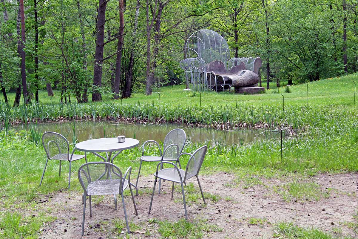 Dennis Oppenheim's artwork "Chair/Pool" displayed by some chairs and a pond in the forest of Europos Parkas, the geographical center of Europe; photo by Ivan Kralj.