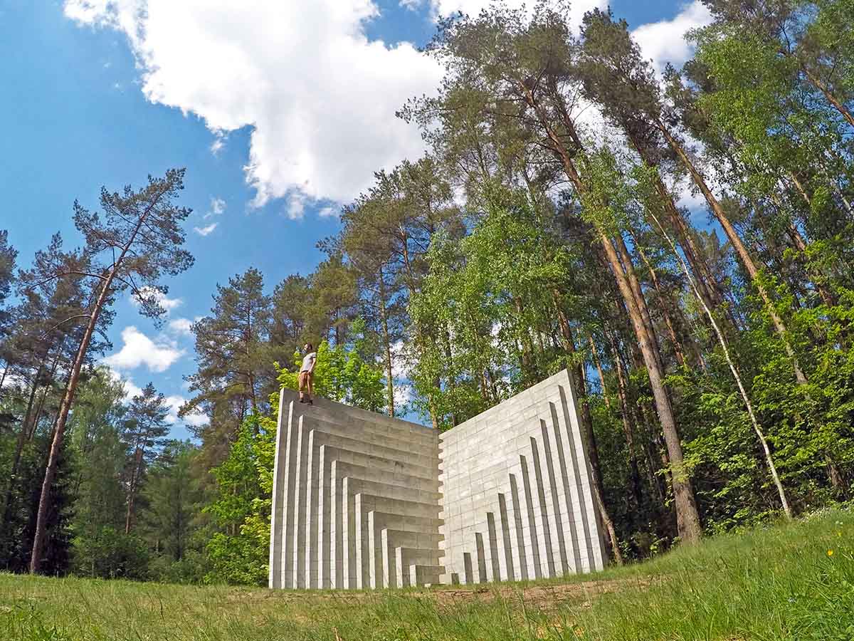 Travel blogger Ivan Kralj standing atop Double Negative Pyramid, the concrete structure created by Sol LeWitt, displayed at Europos Parkas, the geographical center of Europe, a forest near Vilnius, Lithuania; photo by Ivan Kralj.