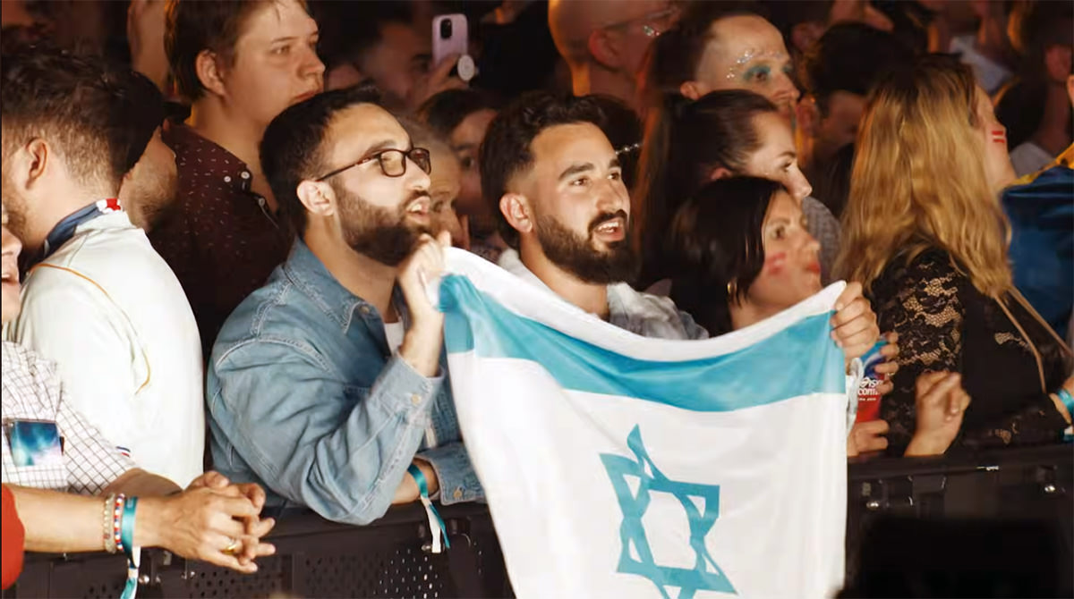 Eurovision fans with Israel flag singing along Noam Bettan during his performance of “Michelle” at Eurovision Song Contest Semi-Final in Vienna, Austria; screenshot Eurovision / EBU / ORF.