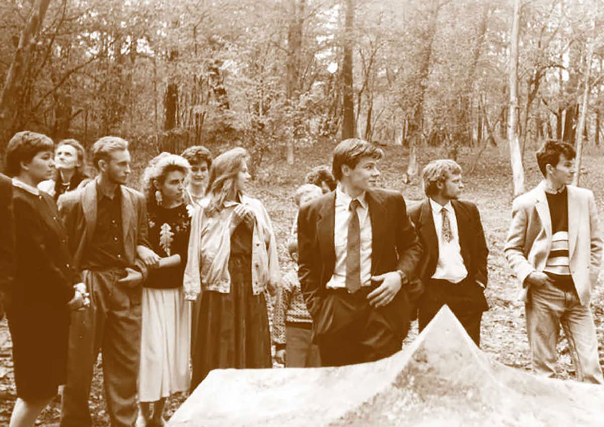 A young Gintaras Karosas (center of the photograph, with a tie), standing besides his "Symbol of Europos Parkas", the first sculpture placed at the geographical center of Europe in Lithuania in 1991; archive photo of Europos Parkas.