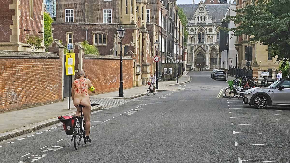A nude cyclist with a message "Can you see me now?" painted in red on his back, riding through Lincoln's Inn Fields in London, UK, during the World Naked Bike Ride protest; photo by Ivan Kralj.