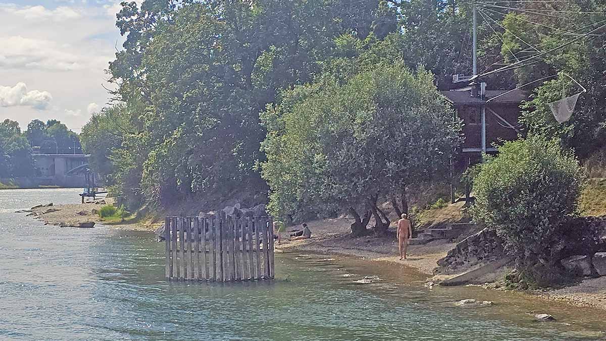 A naked man walking on Goa Beach, one of Basel's naturist beaches on the Rhine, Switzerland; photo by Ivan Kralj.
