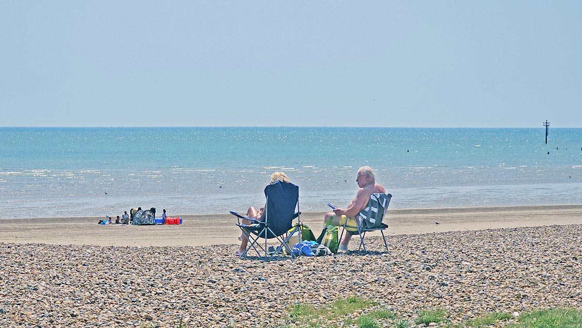 An older couple resting in beach chairs while observing the panorama of the Littlehampton Beach, West Sussex, England, UK; photo by Ivan Kralj.