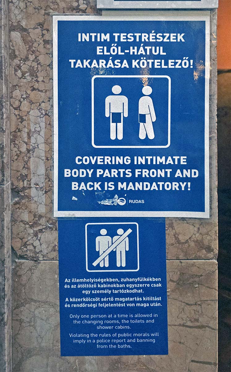 The new sign at Rudas Baths in Budapest instructing visitors that "covering intimate body parts front and back is mandatory!", and another one informing that changing rooms, toilets and shower cabins are single-use only - all violators of the rules of public moral will be reported to the police and banned from the baths.